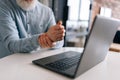 Closeup cropped shot of tired unrecognizable mature older businessman having wrist pain during working at laptop sitting