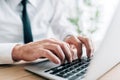 Closeup cropped shot of white collar businessman using laptop computer at office desk