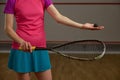 Closeup cropped view on female squash player holding racket and ball Royalty Free Stock Photo