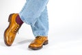 Closeup of Crossed Mens Legs in Brown Oxford Brogue Shoes. Posing in Blue Jeans Against White Background Royalty Free Stock Photo