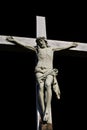 Close-up grey cement crucifix of on black background