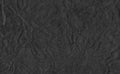 Closeup crumpled black paper texture background, texture. Black paper sheet with space for text ,pattern or abstract background