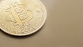 closeup of a cryptocoin bitcoin on a gold background, copy space selective focus