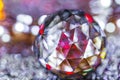 Closeup of crystal glass faceted ball on background of festive lights. Abstract festive, christmas or interior background.