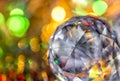 Closeup of crystal glass faceted ball on background of festive lights. Abstract festive, christmas or interior background.