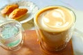 Cup of Caffe Latte with Blurry Madeleine Cakes in Backdrop Royalty Free Stock Photo