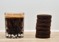 Closeup of a cup of coffee with 6 espresso shots and espresso pucks on the side