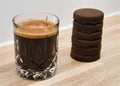 Closeup of a cup of coffee with 6 espresso shots and espresso pucks on the side