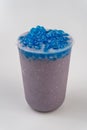 Closeup of a cup of delicious cold purple bubble tea with blue boba on top