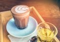 Closeup cup of hot chocolate art on saucer with spoon and tea. Royalty Free Stock Photo