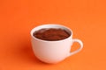 Closeup of a cup of hot chocolate drink on an orange background Royalty Free Stock Photo
