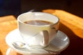 Closeup of a cup of hot tea with smoke on mug put on wooden table and bright light in sunshine in afternoon, Traditional english t Royalty Free Stock Photo