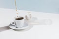 Closeup of cup with pouring coffee, saucer and creamer Royalty Free Stock Photo