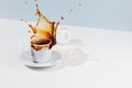 Closeup of cup with splashing coffee, saucer and creamer Royalty Free Stock Photo