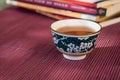 Closeup of a cup of tea and books in an outdoor shaded light