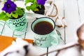 Closeup of a cup of tea on a wooden white table with blur background, front blur. Flat lay. Still life of a flower, a book, a box Royalty Free Stock Photo