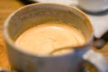 Closeup a cup of unfinished hot coffee Latte in blue ceramic coffee cup