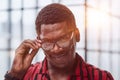 Closeup curious african man with adjusting his glasses for better vision, trying to peep secrets, spying.