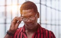 Closeup curious african man with adjusting his glasses for better vision