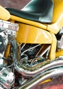 Closeup of a custom design motorbike with chrome leather seat. Details of a yellow luxury motorcycle. An upgrade to a