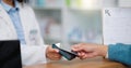 Closeup customer hands using ebanking credit card to pay on contactless nfc machine to collect prescription medication