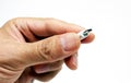 Closeup cut-out shot of a hand holding a micro USB wire on white background