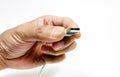 Closeup cut-out shot of a hand holding a USB wire on white background