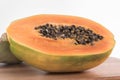 Closeup of cut papaya on a wooden board against a white background Royalty Free Stock Photo