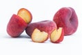 Closeup of cut and whole flat peaches isolated on a white background