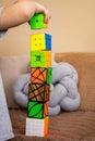 Closeup cute baby boy hands building Rubik's cubes tower having fun playing early development