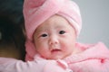 Closeup cute child care with mother indoor. Happy little toddler baby girl smiling lying on bed on white sheet at home looking at Royalty Free Stock Photo