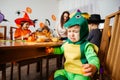 Little baby boy in green fancy costume sitting and crying