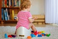 Closeup of cute little 12 months old toddler baby girl child sitting on potty. Kid playing with doll toy. Toilet Royalty Free Stock Photo