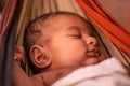 Closeup of cute little new born baby sleeping in cradle made of saree in India