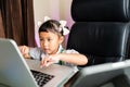 Closeup of a cute southeast Asian girl sitting in front of a laptop