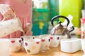 Closeup of cute tea set and woman`s hand pouring hot water into a cup. Tea ceremony. Birthday party and tea with cake Royalty Free Stock Photo