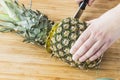 Closeup cutting a pineapple on wooden background Royalty Free Stock Photo