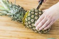 Closeup cutting a pineapple on wooden background