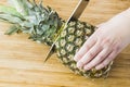 Closeup cutting a pineapple on wooden background Royalty Free Stock Photo