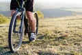 Closeup of cyclist man legs and hands riding mountain bike on outdoor trail in nature Royalty Free Stock Photo