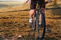 Closeup of cyclist man legs and hands riding mountain bike on outdoor trail in nature Royalty Free Stock Photo