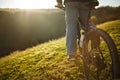 Closeup of cyclist man legs riding mountain bike on outdoor trail on the green field. Royalty Free Stock Photo