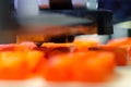 3d printer printing orange plastic pieces