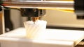 A closeup of a 3D printer working on a desk layering smart materials that change properties when exposed to different