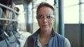 Closeup dairy farm worker in protective glasses posing at milking parlour alone. Royalty Free Stock Photo