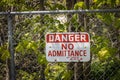 Closeup of the danger sign hanging on the fence in the forest in Niagara Parks in Canada Royalty Free Stock Photo