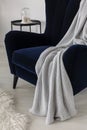 Closeup of dark blue velvet wing back chair with grey blanket in trendy living room Royalty Free Stock Photo