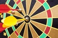 Closeup of a dartboard with yellow and red magnetic darts. Dart in bulls eye of dartboard concept for hitting target dart success Royalty Free Stock Photo