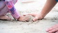 Closeup daughter and father`s hands are making piles of sand at beach by sea. Happy family holiday activities concept. Empty spac Royalty Free Stock Photo