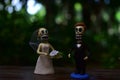 Closeup of dead people dolls getting married on the table in a garden - concept of Halloween